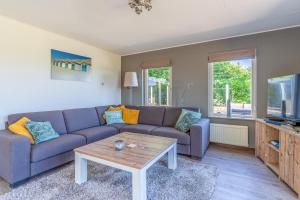 uma sala de estar com um sofá e uma mesa de centro em Villapark Kamperfoelie 71 em De Koog