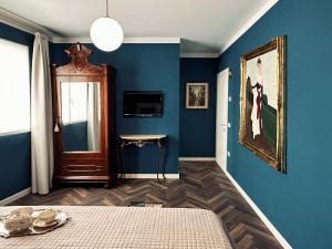 una camera da letto con pareti blu, un letto e una finestra di Villa Danilla a Salzano
