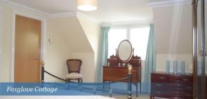 a bedroom with a bed and a dresser and a mirror at Foxglove Cottage in Killean