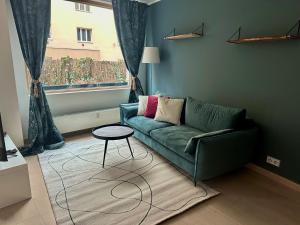 sala de estar con sofá verde y mesa en Apartments Palmovka, en Praga
