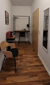 um quarto com uma mesa, uma cadeira e um piso de madeira em City Pension Zwickau em Zwickau