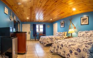 een slaapkamer met 2 bedden en een houten plafond bij White Birches Motel in Ellsworth