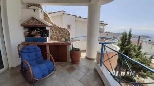 een balkon met 2 stoelen en een bar met uitzicht bij Thalia Luxury Apartment in Kavala