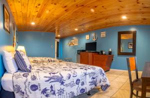 a bedroom with a bed and a wooden ceiling at White Birches Motel in Ellsworth