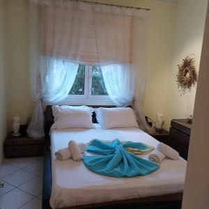 een slaapkamer met een bed met handdoeken en een raam bij Thalia Luxury Apartment in Kavala