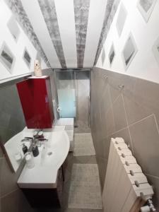 uma casa de banho com um lavatório branco e um chuveiro em B&B Miele em San Fermo della Battaglia