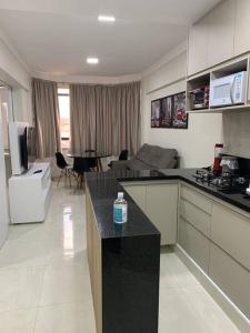 a kitchen and living room with a couch and a table at Flat Mobiliado - Ap 43 L Hirondelle in Campinas