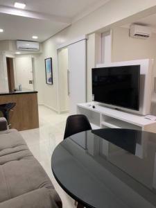 a living room with a flat screen tv on a table at Flat Mobiliado - Ap 43 L Hirondelle in Campinas