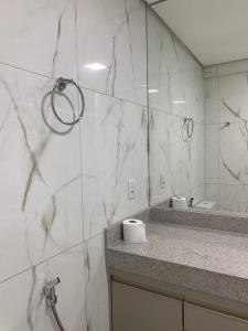a bathroom with a marble counter and a mirror at Flat Mobiliado - Ap 43 L Hirondelle in Campinas