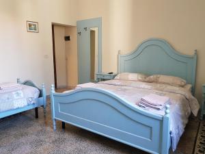 una camera con letto blu e specchio di B&B Le Mura a Grosseto