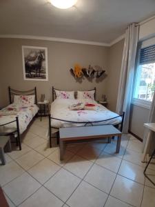 a bedroom with two beds and a window at B&B Miele in San Fermo della Battaglia