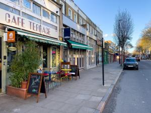 a city street with a cafe terrace on the sidewalk at homely - King's Cross Central London Apartments in London
