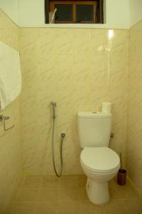 W łazience znajduje się biała toaleta i prysznic. w obiekcie TIKI TAKA w mieście Kandy
