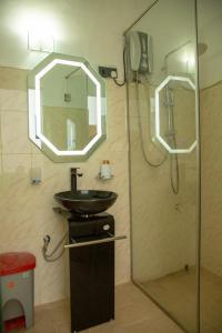 W łazience znajduje się umywalka oraz prysznic z lustrem. w obiekcie TIKI TAKA w mieście Kandy