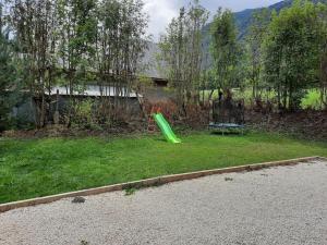 a green slide in the grass in a yard at Appartement tout confort , centre Loudenvielle in Loudenvielle