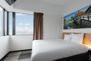 a hotel room with a bed and a large window at easyHotel Amsterdam Zaandam in Zaandam