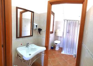 La salle de bains est pourvue d'un lavabo et de toilettes. dans l'établissement Villaggio dei Balocchi, à Castelbuono