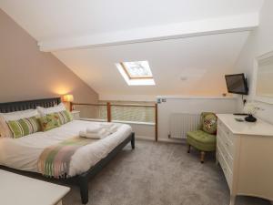 a bedroom with a bed and a desk and a television at Lark Meadow in Carnforth