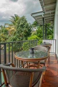 un patio con mesas y sillas en el balcón en TIKI TAKA en Kandy