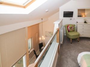 a bedroom with a staircase and a green chair at Lark Meadow in Carnforth