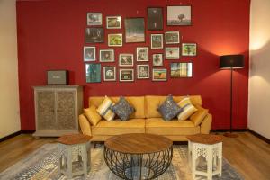 salon z kanapą i czerwoną ścianą w obiekcie TIKI TAKA w mieście Kandy