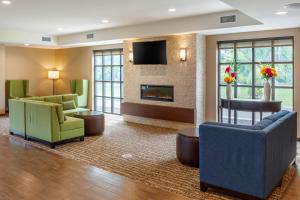 a hotel lobby with chairs and a fireplace at Comfort Inn & Suites Amish Country in Gap