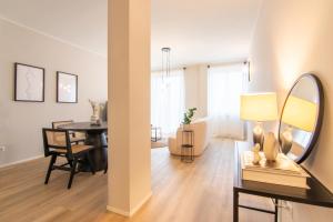 a living room with a table and a mirror at Appartamento Regina - Lake Como View in Gravedona