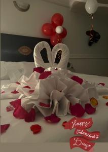 a bed with a wedding cake and red flowers at Aparta Hotel Plenitud in Palmira