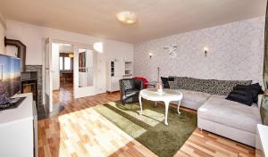 ein Wohnzimmer mit einem Sofa und einem Tisch in der Unterkunft Apartment Sir George in Garmisch-Partenkirchen