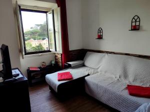 a living room with a couch and a window at Casas da Biquinha in Sintra