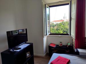a room with a television and a large window at Casas da Biquinha in Sintra