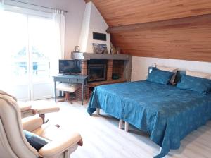 - une chambre avec un lit bleu et une télévision dans l'établissement Chambres d'hôtes Era Honteta, à Artigues