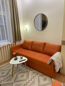 uma sala de estar com um sofá laranja e um espelho em Apartment Begonia em Sarajevo