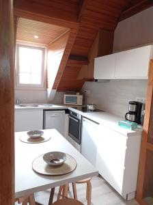 una pequeña cocina con electrodomésticos blancos y una mesa en Chambres d'hôtes Era Honteta, en Artigues