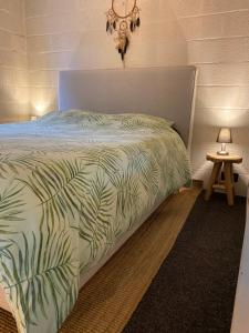 a bedroom with a bed with a green comforter at Le petit ours de Coo in Stavelot
