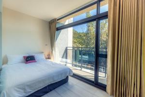 Un dormitorio con una cama y una ventana grande. en Peachland, en Puli