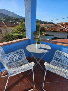 two chairs and a table on a balcony at VILLA VILLACOLLE in Procchio