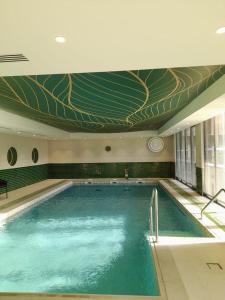 a large swimming pool with a mural on the ceiling at DOMITYS L'ALLIACEE in Achères