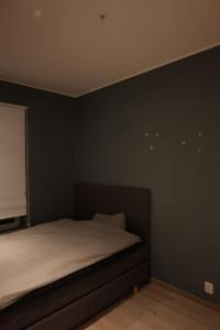 a bedroom with a bed with a black wall at Moderne Leilighet med 2soverom Sentral beliggenhet in Asker