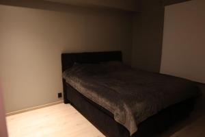 Un pequeño dormitorio con una cama en la esquina en Moderne Leilighet med 2soverom Sentral beliggenhet en Asker