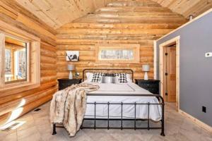 1 dormitorio con 1 cama en una habitación con paredes de madera en Studio apartment at Sugarloaf Log House en Dickerson