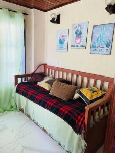 a bedroom with a wooden bed with pillows on it at Casa Azul na Praia do Verão Vermelho in Cabo Frio