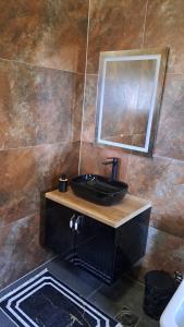 bagno con lavandino nero e specchio di Luxos Villa a Ferizaj