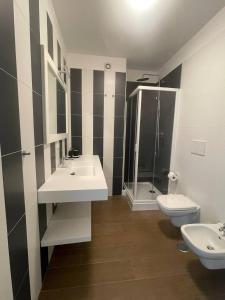 a bathroom with two sinks and a shower and a toilet at Tre cancelli rooms in Potenza