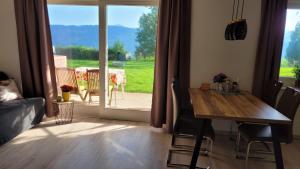 d'un salon avec une table et une porte coulissante en verre. dans l'établissement "Seeblick und mehr", à Millstatt