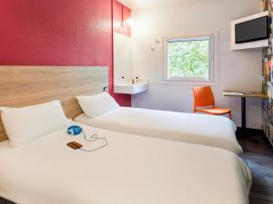 Habitación de hotel con 2 camas y lavamanos en hotelF1 Mulhouse Bâle Aéroport en Haberhaeuser