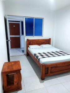 Tauramena的住宿－HOTEL EL VAQUIANO，一间卧室配有一张木床和一张桌子