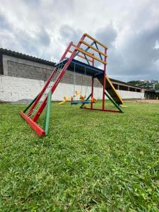 a playground with a slide on the grass at Pousada Santa Terezinha in Garopaba