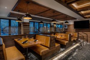 a restaurant with wooden tables and chairs and a flat screen tv at Teton Mountain Lodge and Spa, a Noble House Resort in Teton Village
