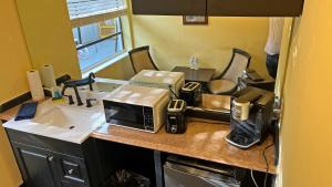 a kitchen counter with a microwave and a sink at Avalon Resort of Deerfield Beach in Deerfield Beach